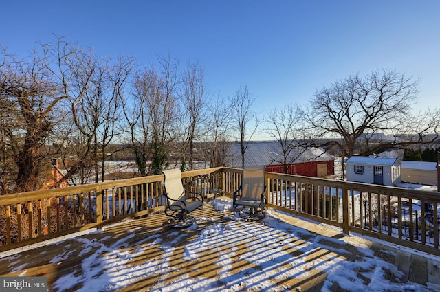 snow covered deck with a storage unit