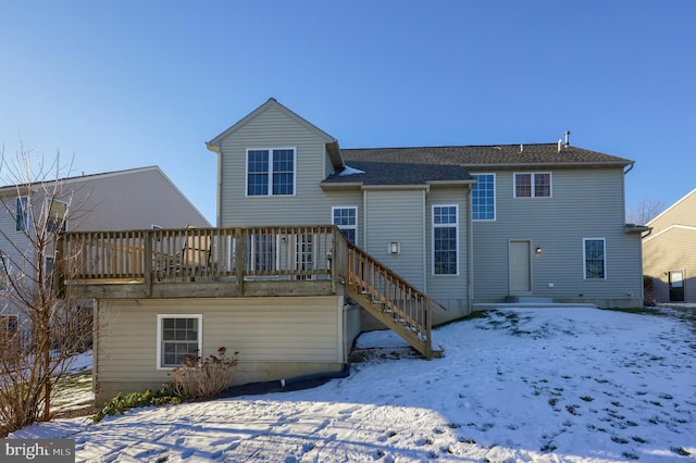 snow covered back of property featuring a wooden deck