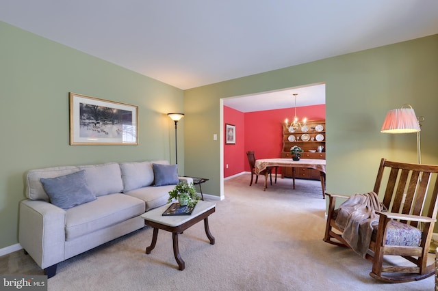 carpeted living room featuring an inviting chandelier