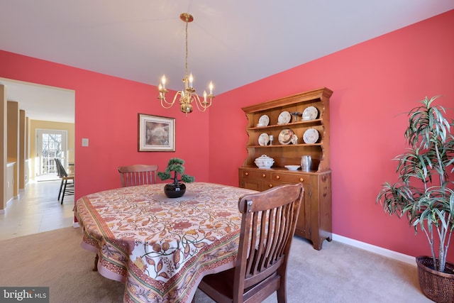 dining area with an inviting chandelier and light carpet