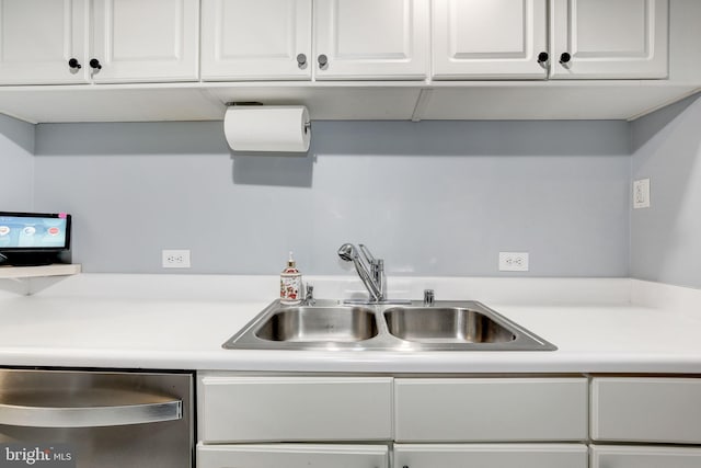 kitchen with dishwasher, white cabinets, and sink