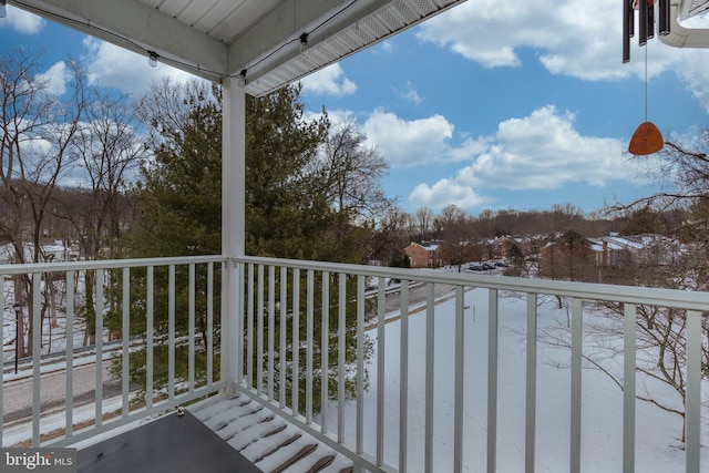 view of snow covered back of property