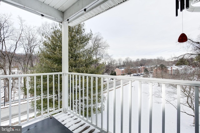 view of snow covered back of property