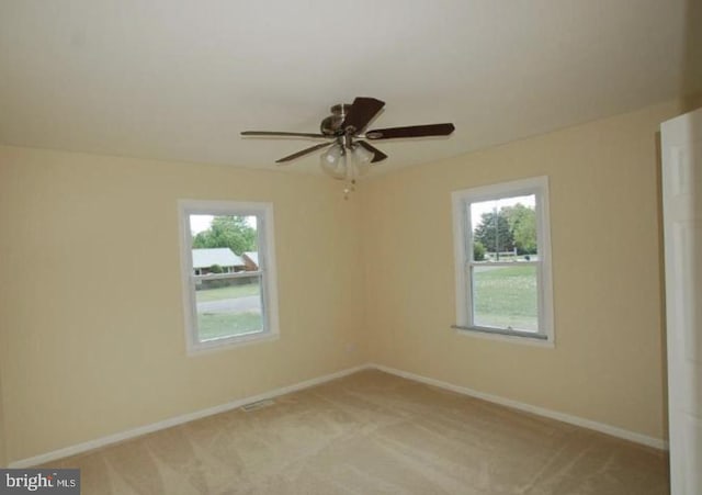 carpeted spare room featuring ceiling fan