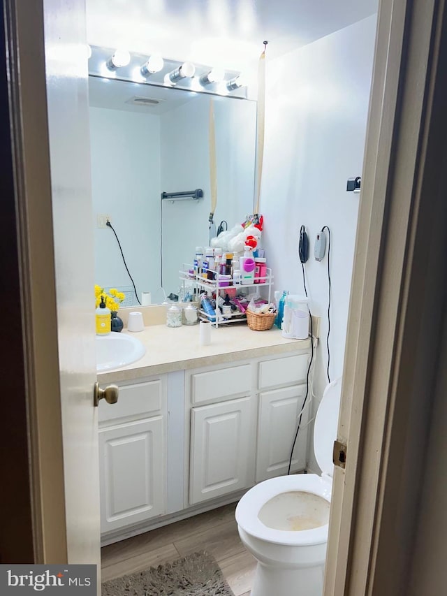 bathroom featuring hardwood / wood-style flooring, vanity, and toilet