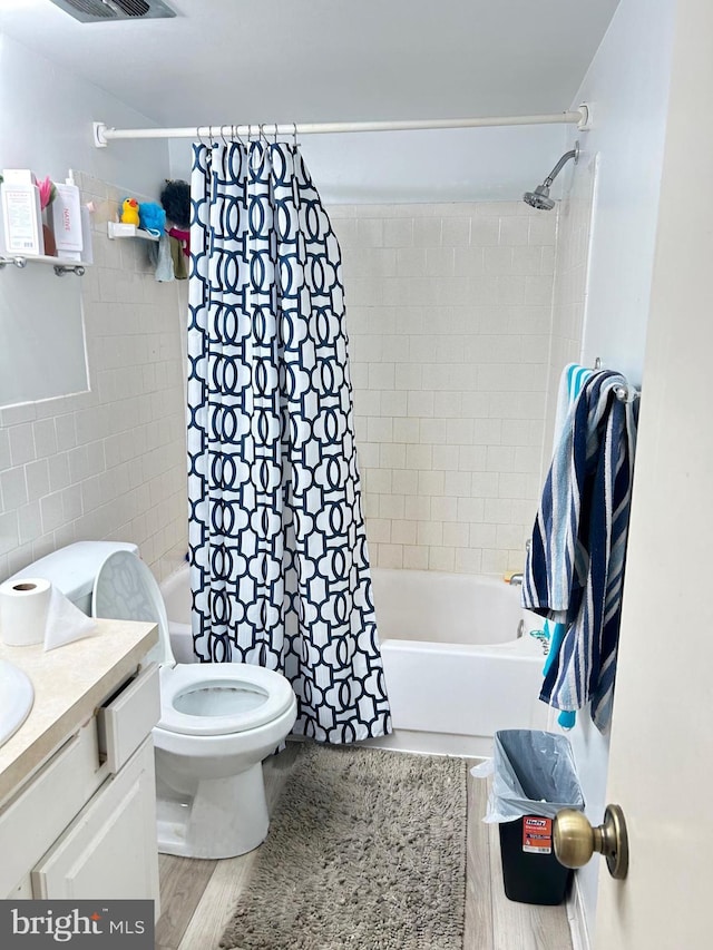 full bathroom with shower / bath combo, vanity, toilet, and tile walls