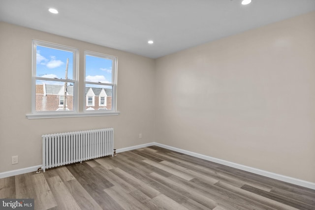 empty room featuring light hardwood / wood-style flooring and radiator heating unit