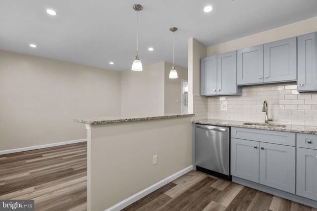 kitchen with kitchen peninsula, stainless steel dishwasher, light stone countertops, decorative backsplash, and sink