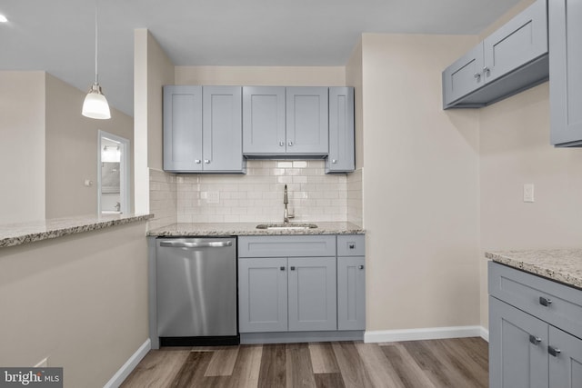 kitchen featuring light stone countertops, dishwasher, dark hardwood / wood-style floors, decorative backsplash, and sink