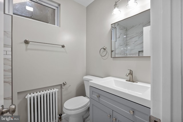 bathroom featuring radiator, vanity, toilet, and walk in shower