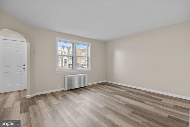 foyer featuring light wood-type flooring and radiator heating unit