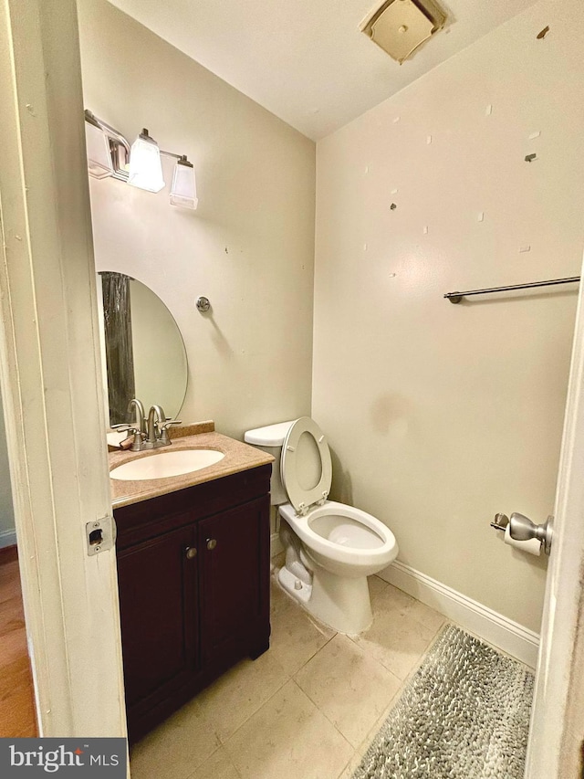 bathroom featuring tile patterned flooring, vanity, and toilet