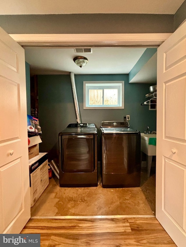 washroom featuring washing machine and clothes dryer and sink