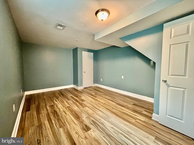 additional living space with light hardwood / wood-style flooring