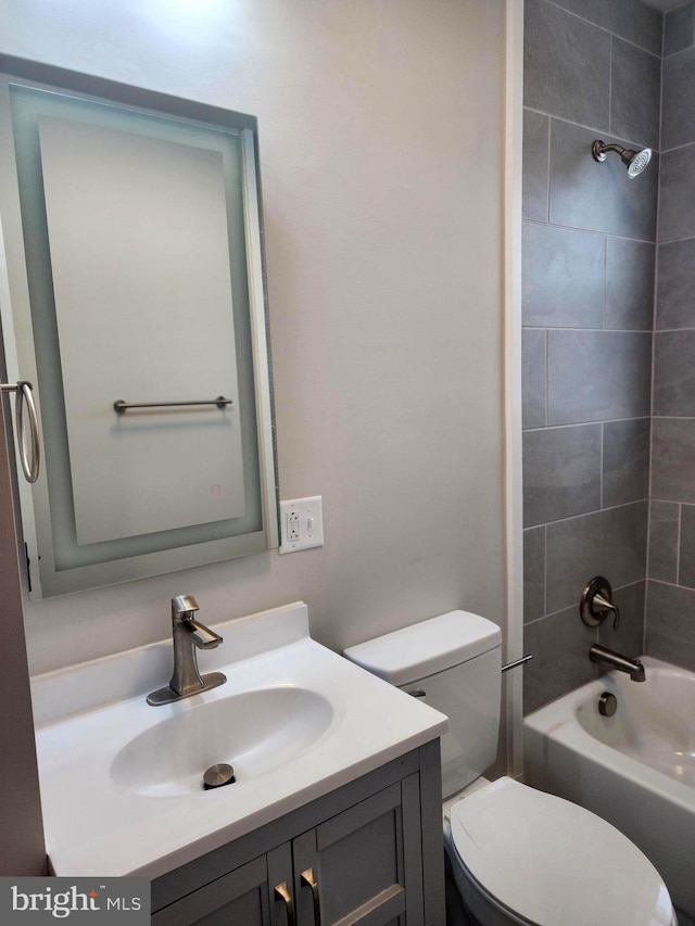 full bathroom with vanity, tiled shower / bath combo, and toilet