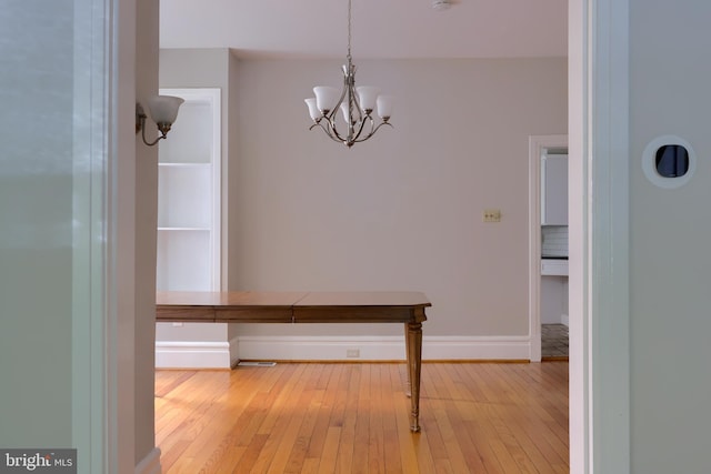 corridor featuring light hardwood / wood-style flooring and a notable chandelier