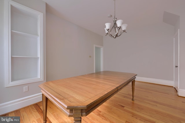 dining room featuring hardwood / wood-style flooring and an inviting chandelier