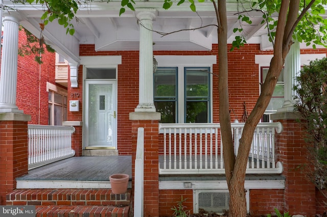 view of exterior entry featuring covered porch