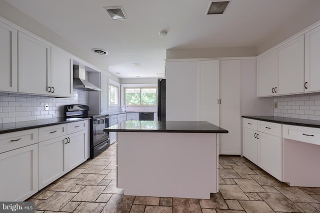 kitchen featuring wall chimney range hood, a kitchen island, tasteful backsplash, white cabinets, and black appliances