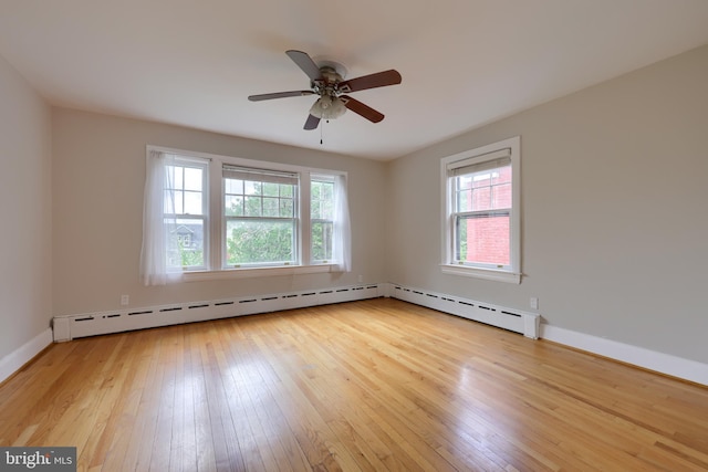 empty room with wood-type flooring, ceiling fan, and a healthy amount of sunlight