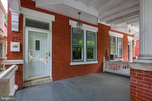 entrance to property featuring cooling unit and a porch