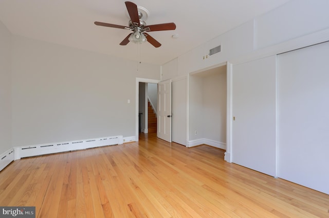 empty room with ceiling fan, light hardwood / wood-style floors, and a baseboard heating unit