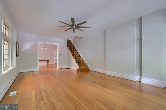 unfurnished living room featuring ceiling fan with notable chandelier, light hardwood / wood-style floors, and a baseboard radiator