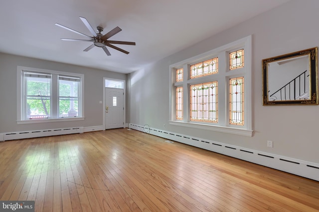 foyer entrance with light hardwood / wood-style flooring, ceiling fan, and a baseboard heating unit