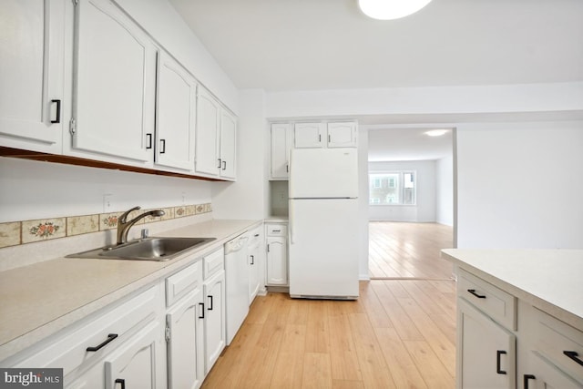 kitchen featuring sink, white appliances, white cabinets, and light hardwood / wood-style flooring