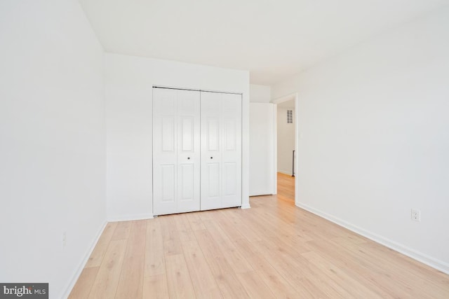 unfurnished bedroom with light hardwood / wood-style floors and a closet