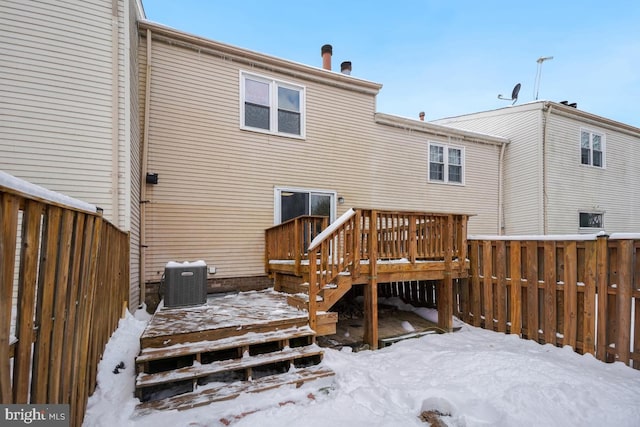 snow covered property with a deck and cooling unit