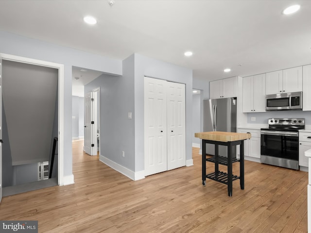 kitchen featuring white cabinets, light wood-type flooring, and appliances with stainless steel finishes