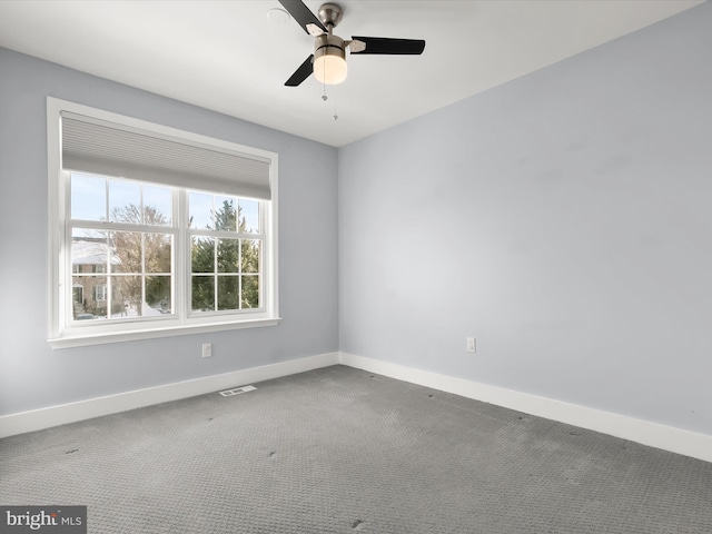 carpeted spare room featuring ceiling fan