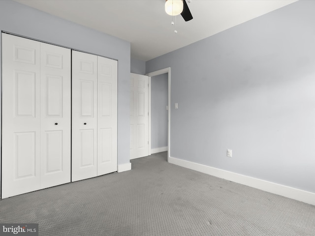 unfurnished bedroom featuring dark carpet, a closet, and ceiling fan