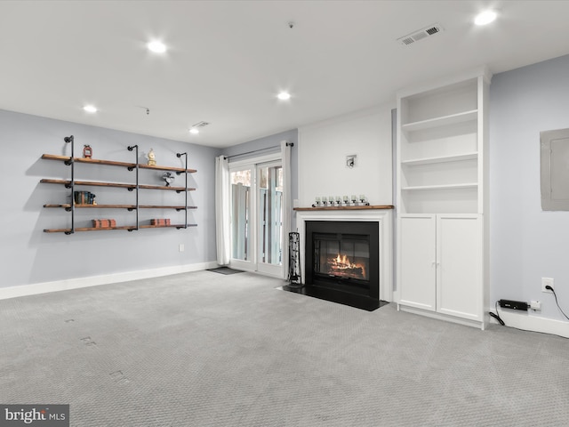 unfurnished living room with electric panel and light colored carpet