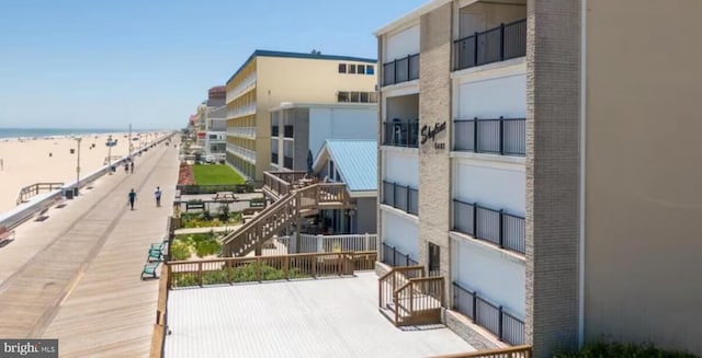 view of building exterior with a water view and a beach view