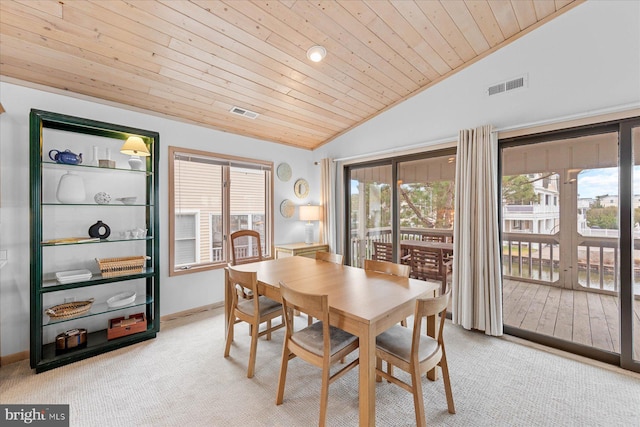 dining room featuring light carpet, wood ceiling, and vaulted ceiling