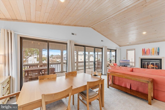 dining room featuring light carpet, wood ceiling, and vaulted ceiling