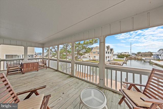 sunroom / solarium featuring a water view and a wealth of natural light