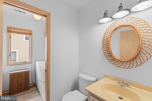 bathroom with hardwood / wood-style floors, vanity, and toilet