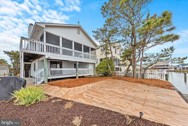 back of property featuring a deck with water view