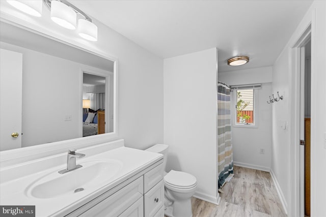 bathroom with vanity, hardwood / wood-style flooring, toilet, and walk in shower