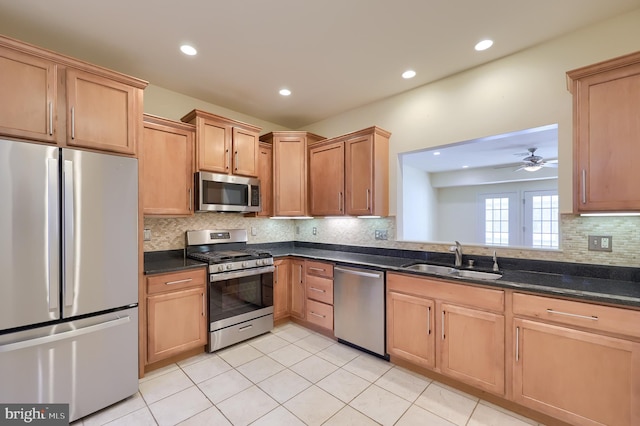 kitchen with backsplash, stainless steel appliances, ceiling fan, sink, and light tile patterned floors