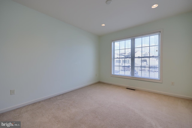 spare room featuring light carpet