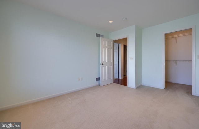 unfurnished bedroom with light carpet and a closet