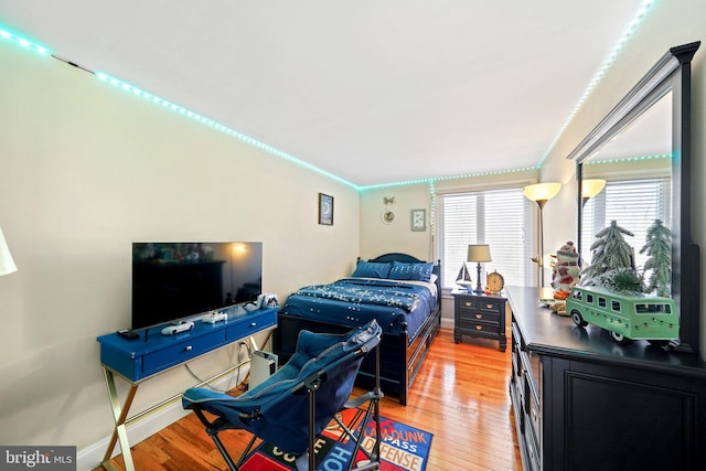 bedroom featuring ornamental molding and light hardwood / wood-style flooring