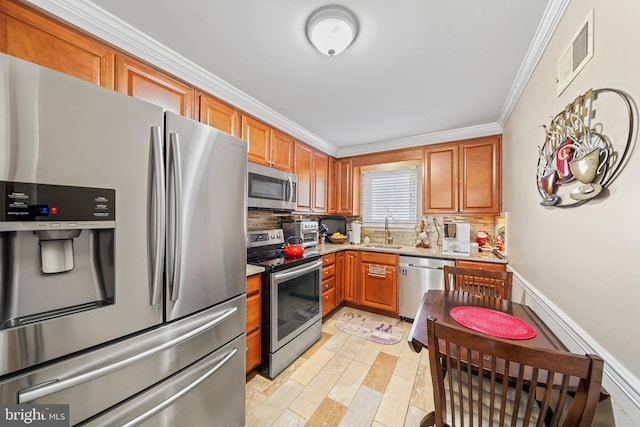 kitchen with sink, stainless steel appliances, crown molding, and decorative backsplash