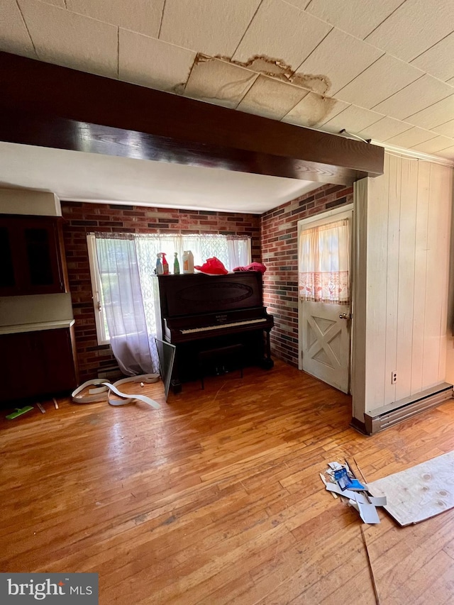 interior space featuring wooden walls, brick wall, and hardwood / wood-style flooring