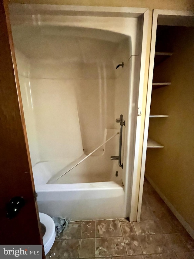 bathroom featuring washtub / shower combination and toilet