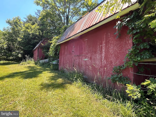 view of property exterior with a lawn and an outbuilding